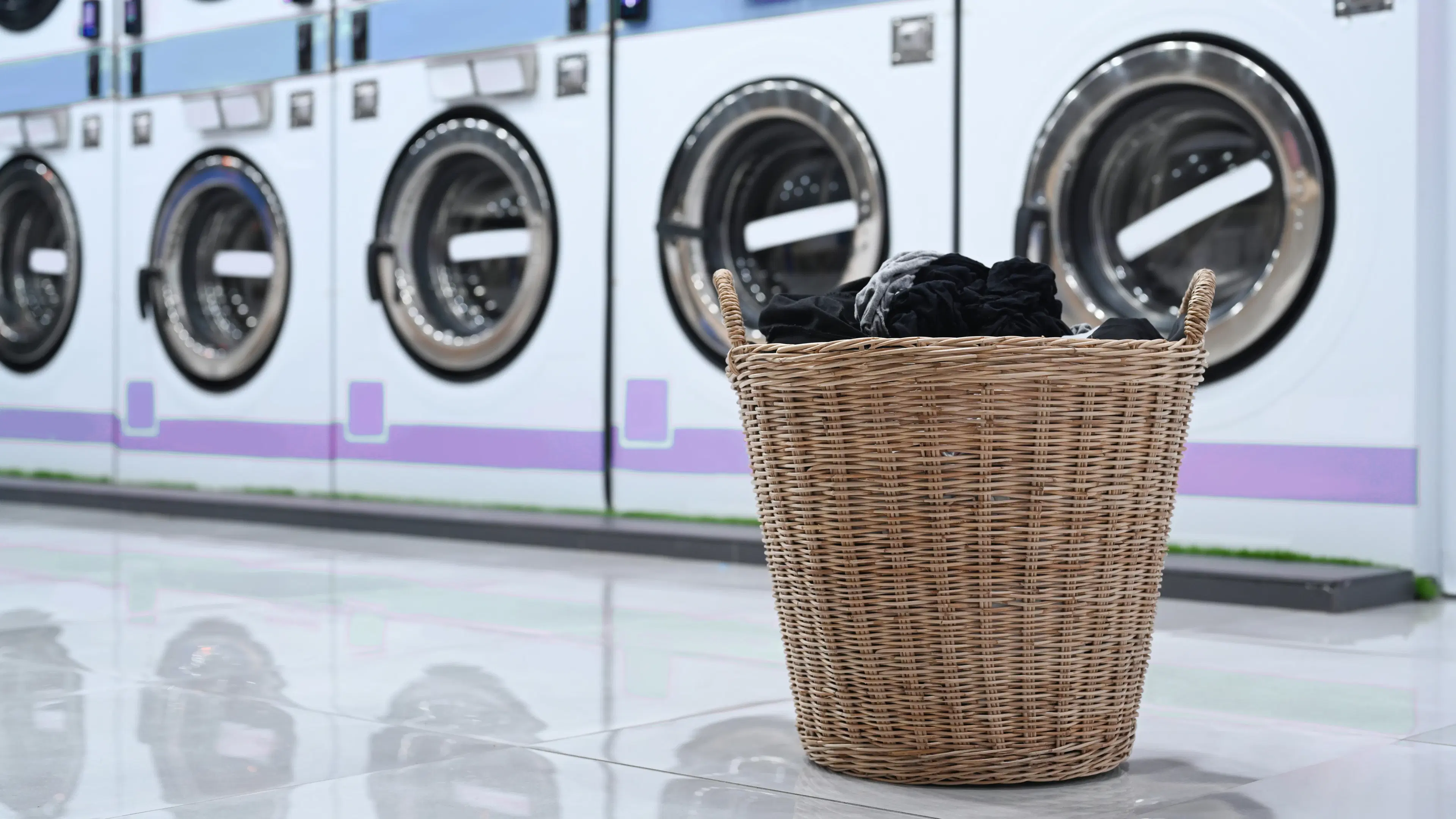 A woman smiling while holding a basket of fresh laundry