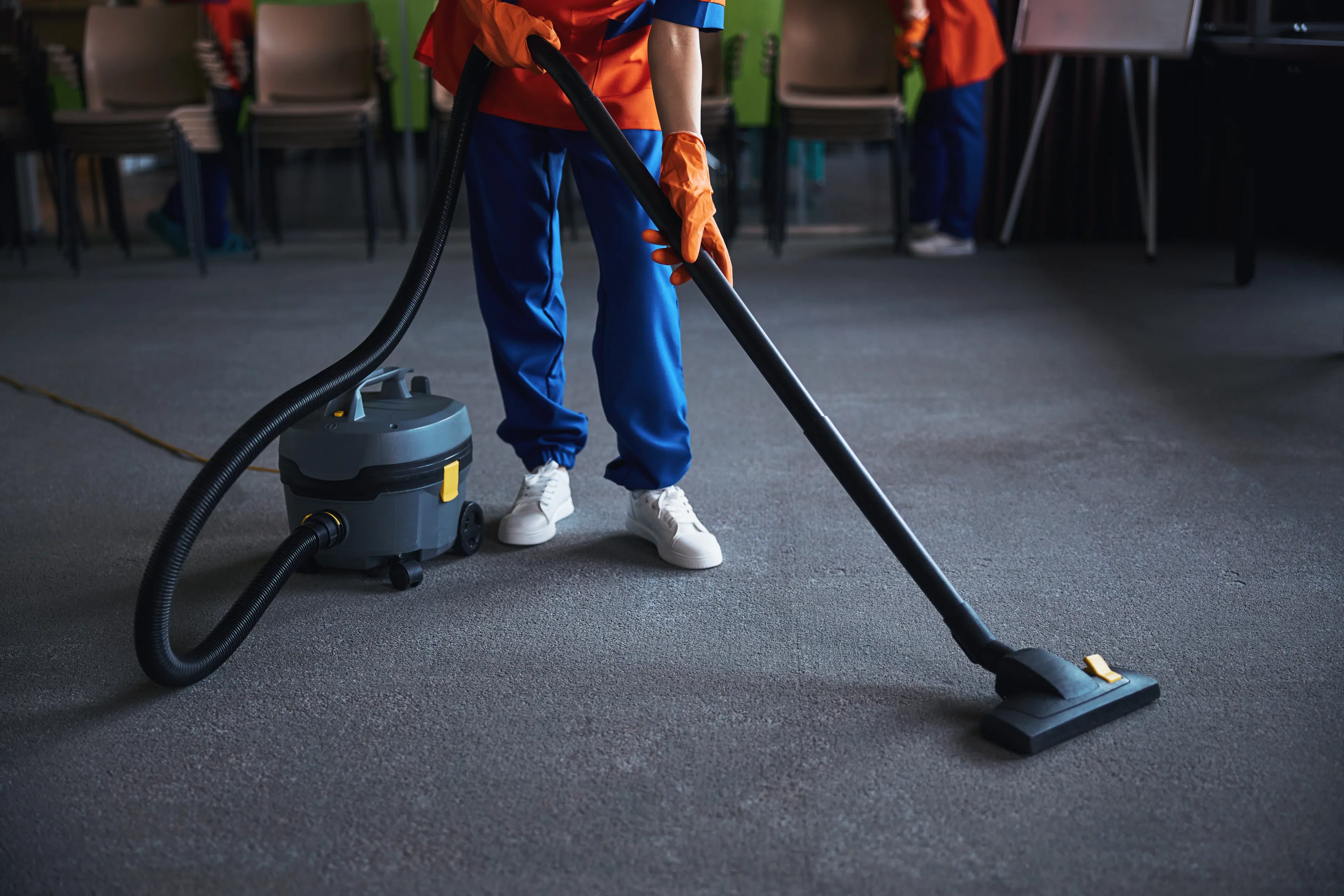 A woman professionally steaming a blue shirt